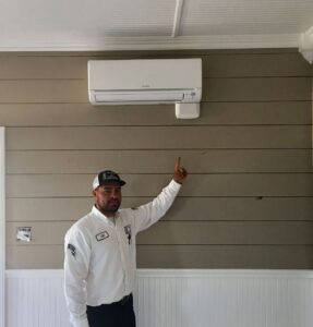 A technician standing under an air conditioner.